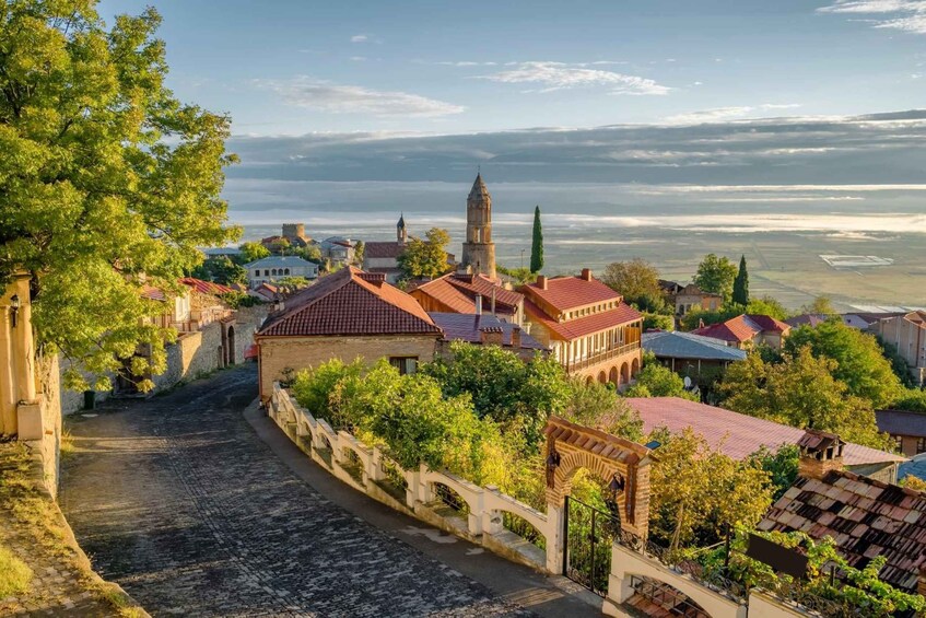A historic town with cobblestone streets, traditional buildings, and a prominent church tower. 3