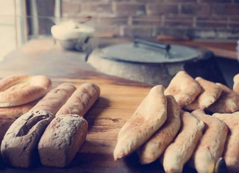 A wooden table with several loaves of bread. 5
