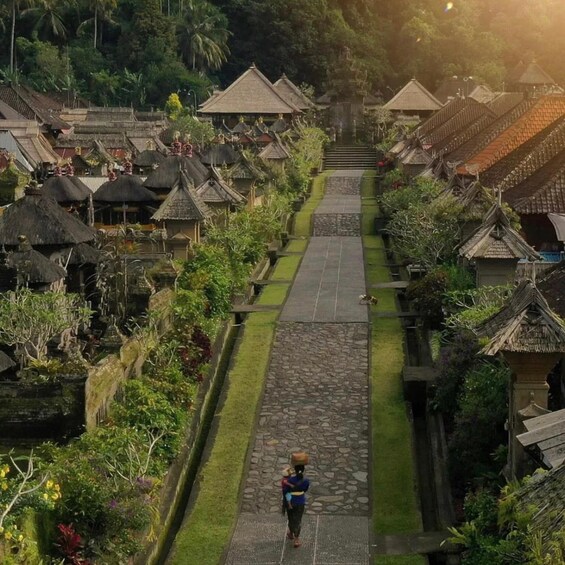 A village with traditional thatched-roof houses and a central stone pathway. 3