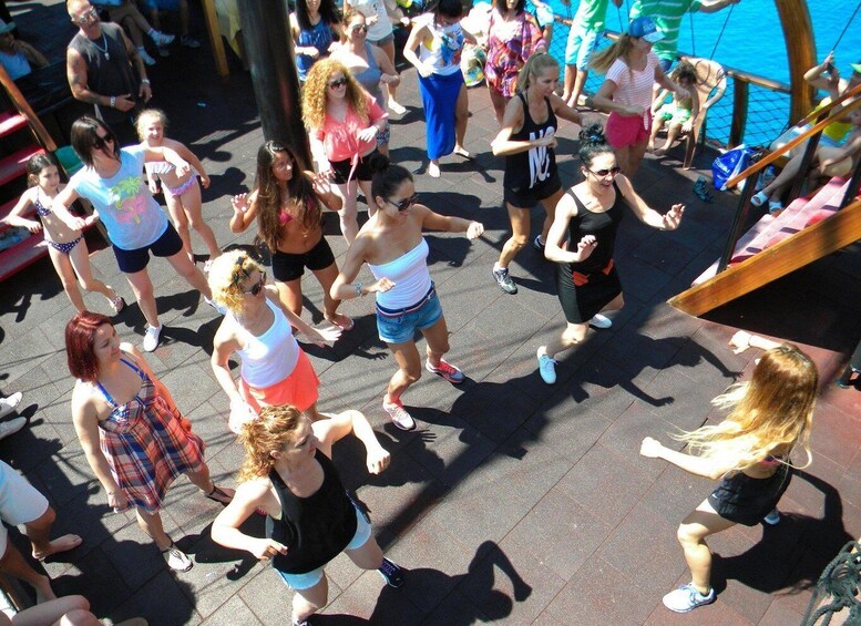 A group of people dancing outdoors on a sunny day. 2