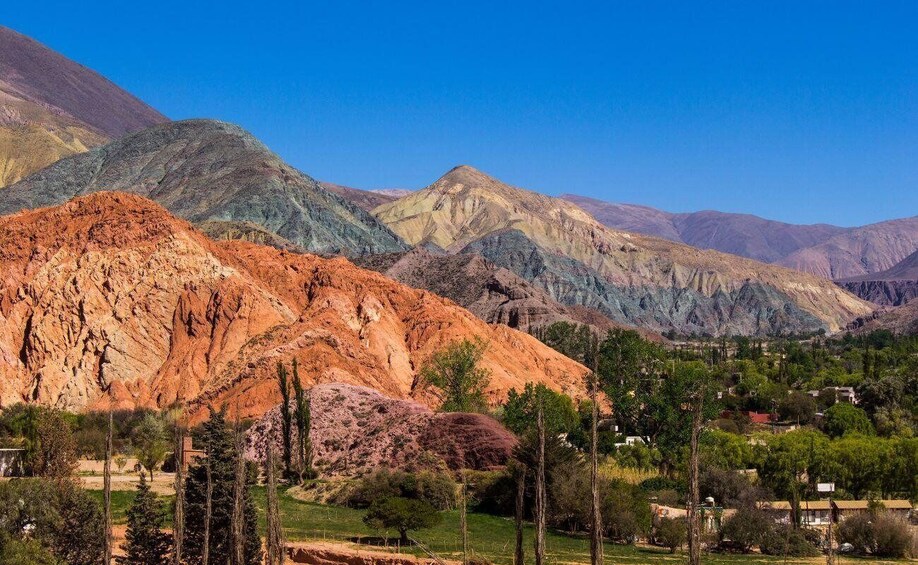 A mountainous landscape with a village nestled at its base. 4