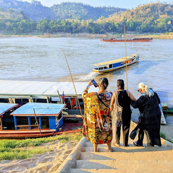 A river with boats, a dock, and people by the water. 3