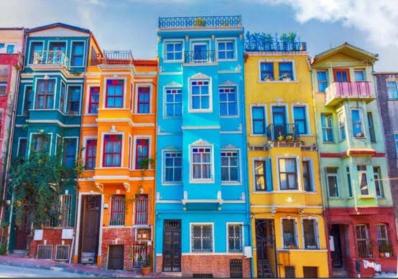 A row of colorful Victorian-style houses with distinct pastel colors and ornate architectural details. 5