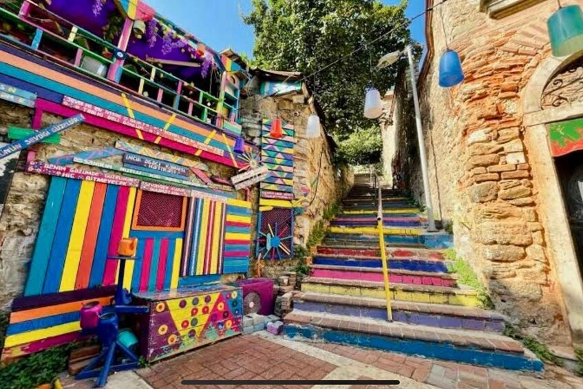 A colorful staircase with vibrant stripes leading up to a building with a sign. 3