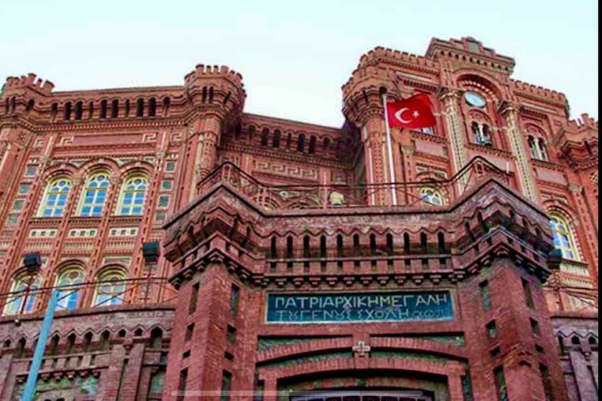 A large, ornate building with intricate brickwork and a prominent flag. 2