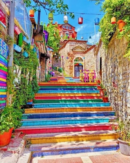 A colorful staircase leading up to a stone building with a red roof. 4
