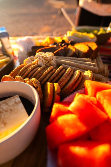 A variety of snacks including crackers, cheese, and watermelon slices on a table. 5