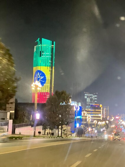 A brightly lit building with vertical stripes of green, yellow, and red colors. 2