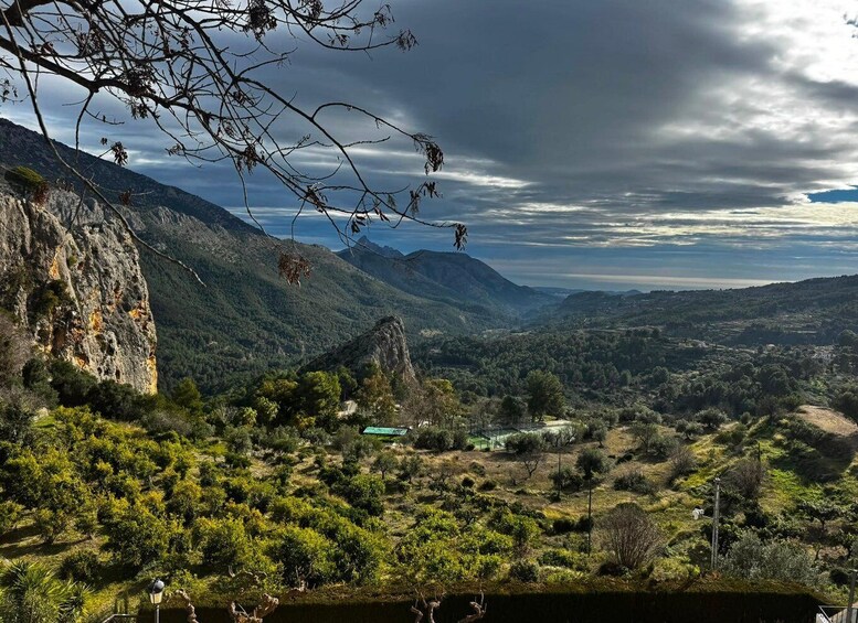A mountainous landscape with a valley, a body of water, and a small building. 3