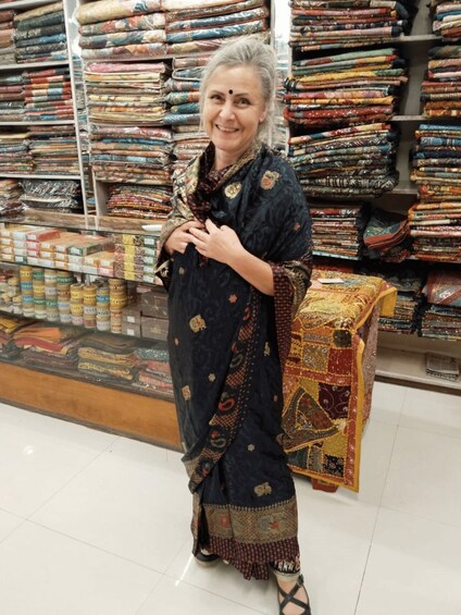 A person in a store with shelves of textiles and fabric rolls. 5