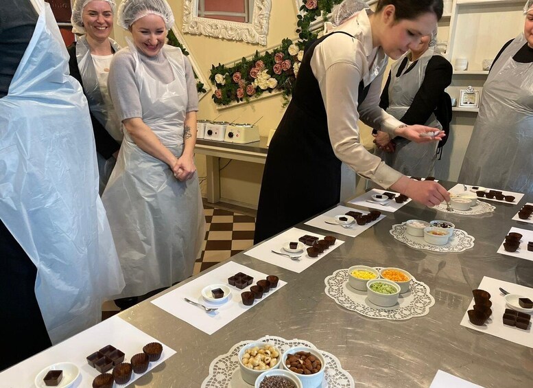 A group of people in a kitchen preparing desserts. 5