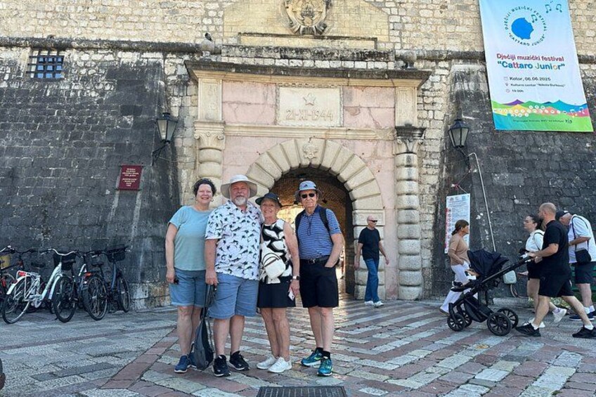 Un grupo de personas frente a un arco de piedra histórico con bicicletas estacionadas cerca. 5