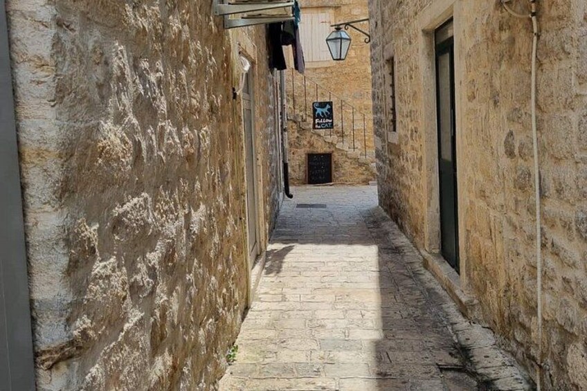 Un estrecho callejón de piedra con un cartel que indica una zona de estacionamiento. 2