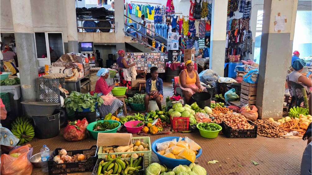 A bustling outdoor market with vendors selling fresh produce and colorful clothing. 1