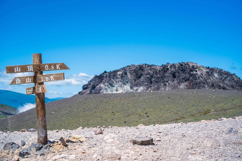 A wooden signpost with directional markers in a rocky landscape. 4