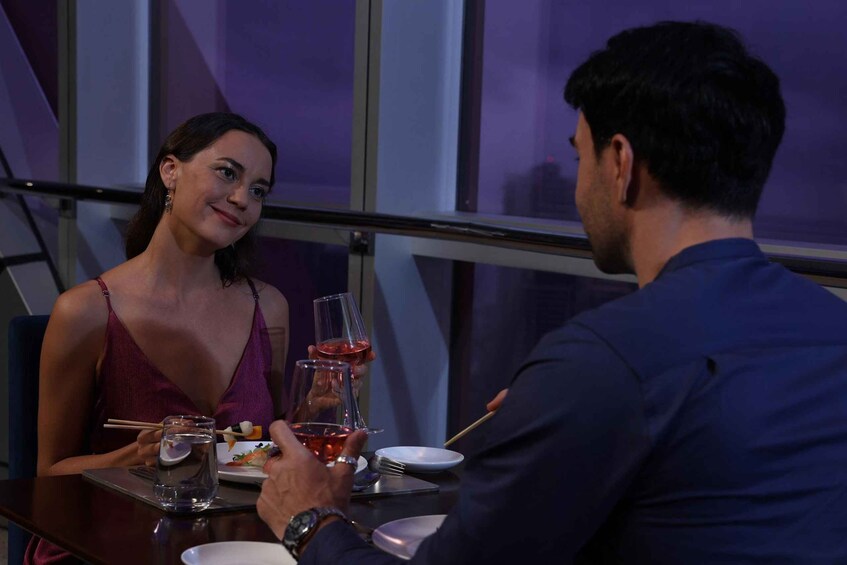 Two people dining at a table with wine glasses and chopsticks. 5