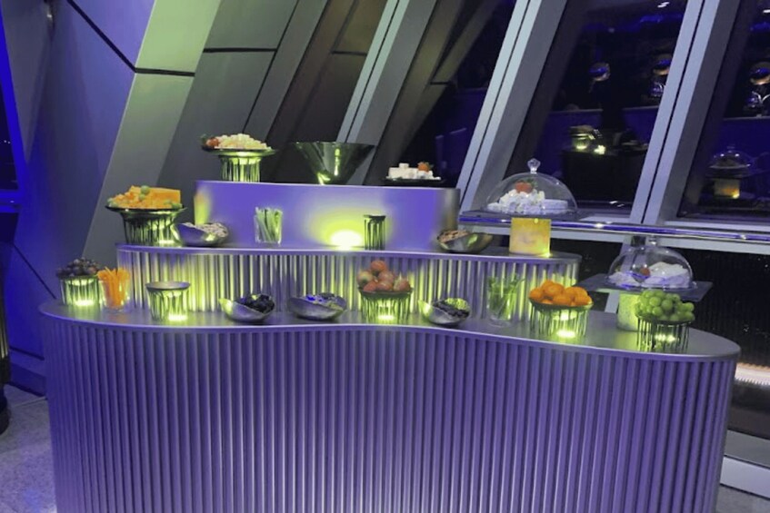 A buffet with various food items and a decorative glass dome. 4