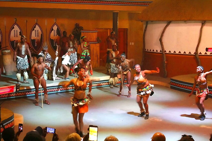 A cultural dance performance with performers in traditional attire. 2