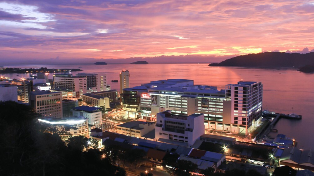A cityscape at dusk with buildings and a waterfront. 3