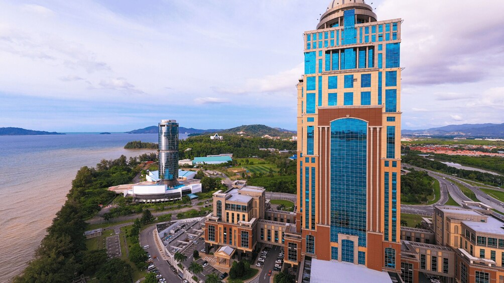 A modern cityscape with a prominent tower, a round building, and a body of water. 5