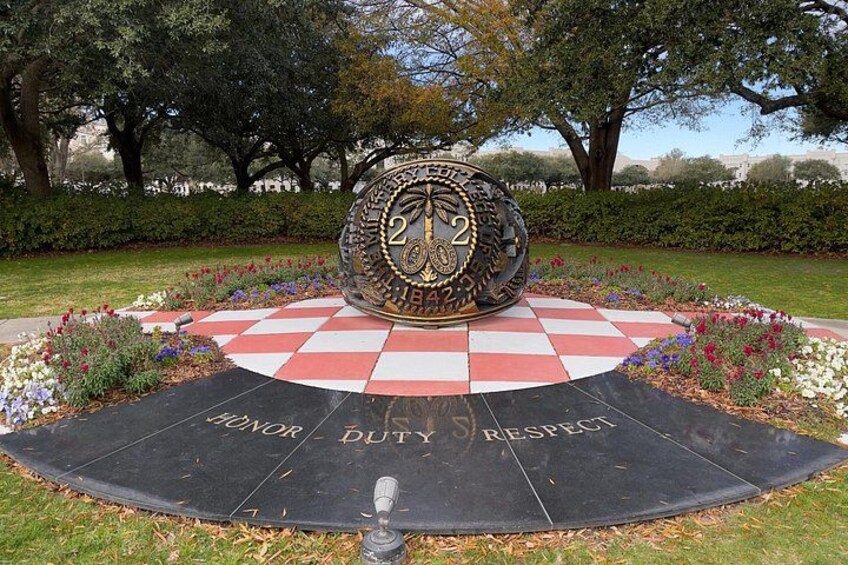 A large clock surrounded by a checkered pavement with inscriptions. 2