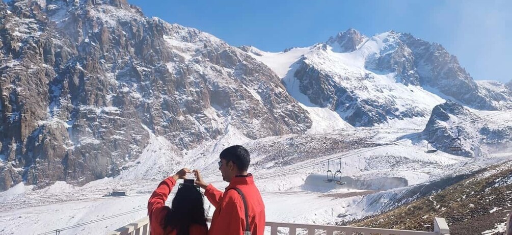 A mountainous landscape with snow-covered peaks and a ski lift in operation. 1