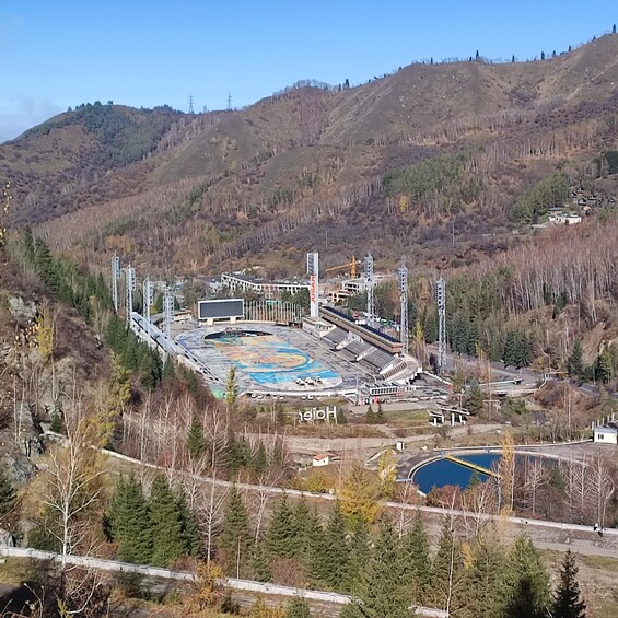 A stadium surrounded by hills and trees. 3