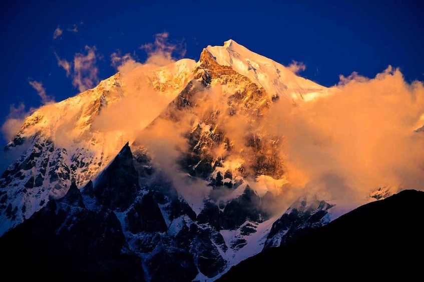 A snow-capped mountain peak with a clear sky and clouds. 1