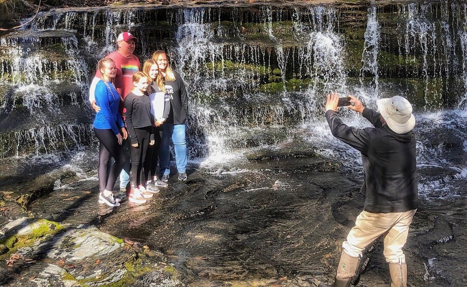 A waterfall with people standing and taking photos. 5