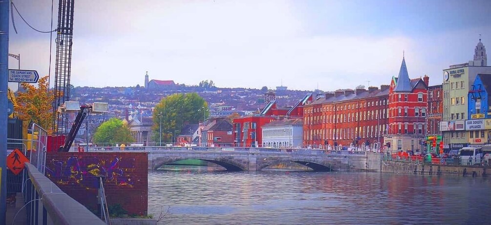 A bridge over a river with buildings and a hill in the background. 4