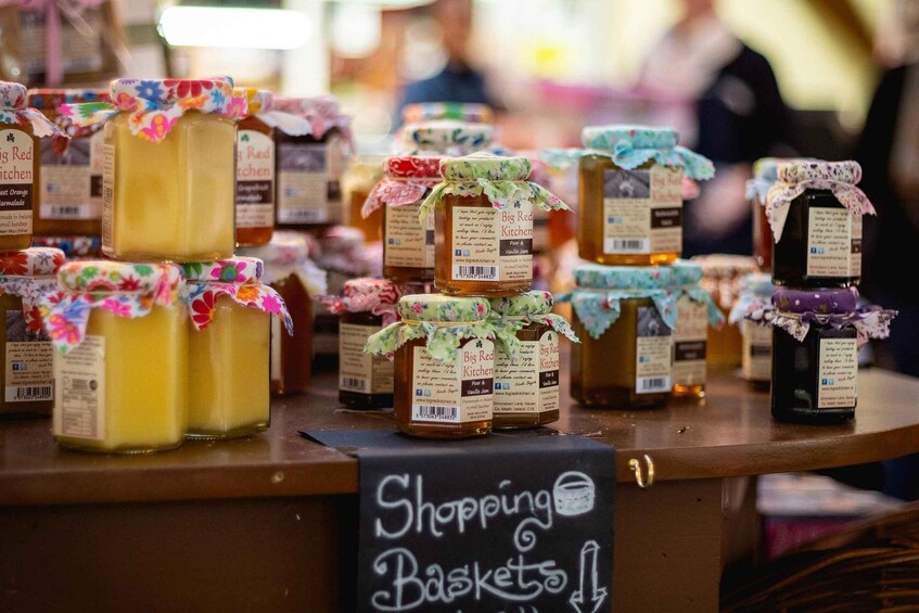A display of jars with floral labels at a market stall. 3
