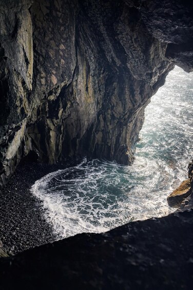 A rocky cave opening to a turbulent sea. 5