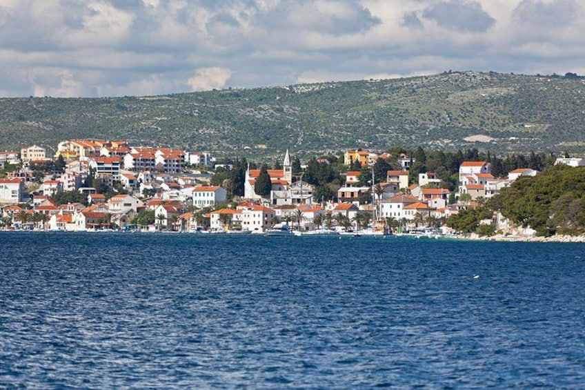 Una località costiera con edifici, uno specchio d'acqua e un paesaggio collinare sullo sfondo. 3