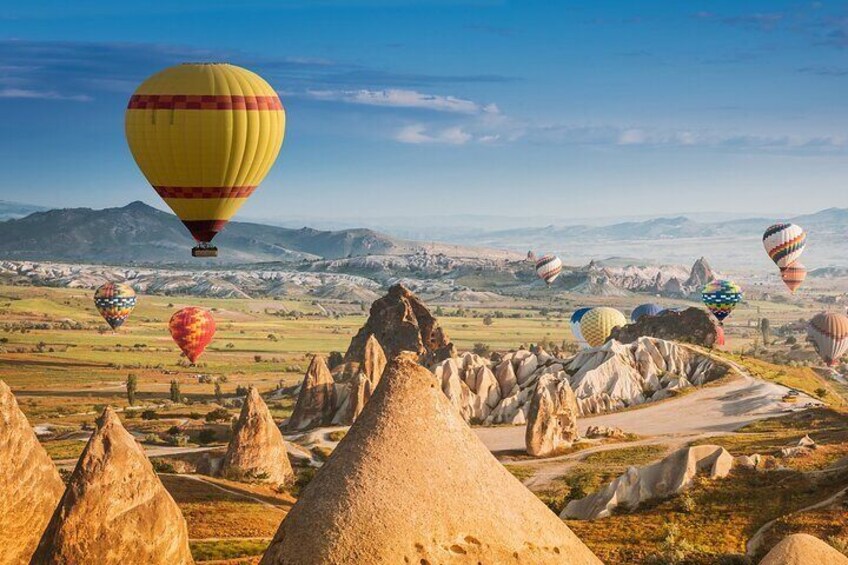 Hot air balloons over a landscape with unique rock formations. 2