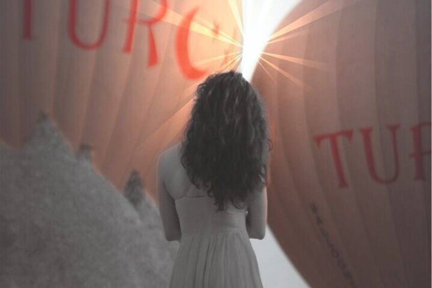 A person in a white dress standing in front of a large red banner with the word 'TURF' partially visible. 1