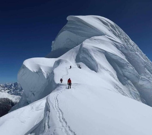 A snow-covered mountain with a large overhang and a clear sky. 4