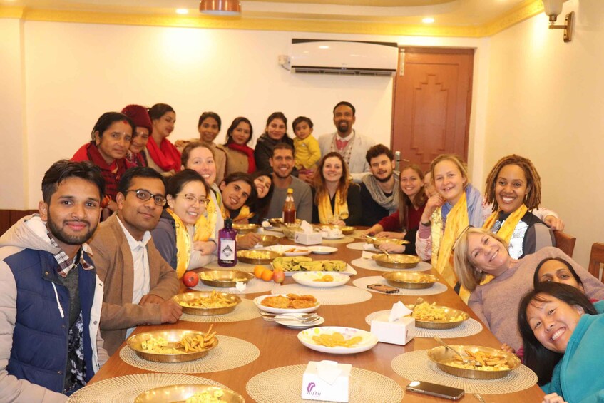 A group of people sitting around a table with food and drinks. 1