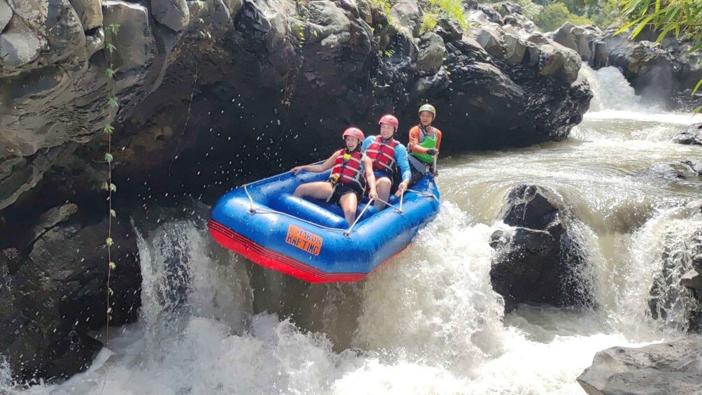 A group of people rafting down a river with rapids. 1
