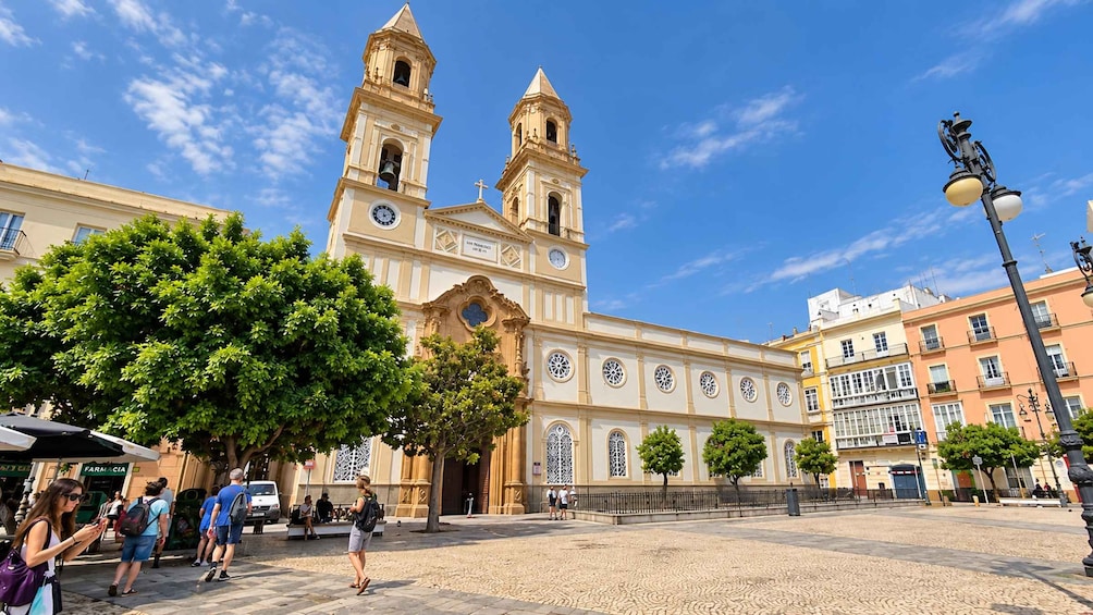 A historic church with two bell towers, surrounded by trees and buildings. 4