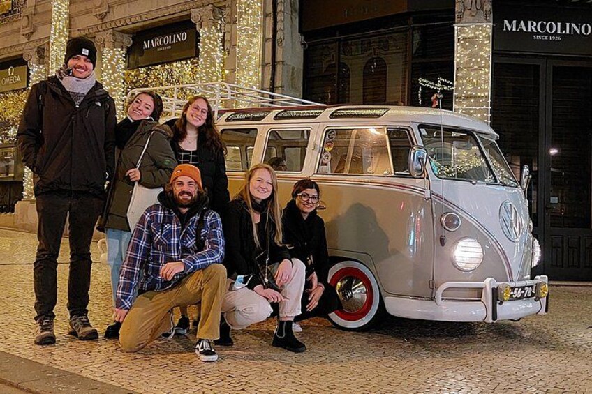 Un groupe de personnes posant devant un vieux camping-car Volkswagen. 3