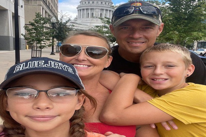 A family of four in front of a large government building with columns. 4