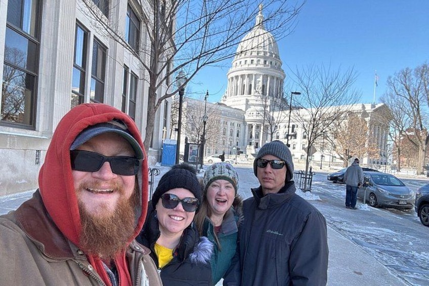 A group of people standing in front of a large government building with a dome. 5