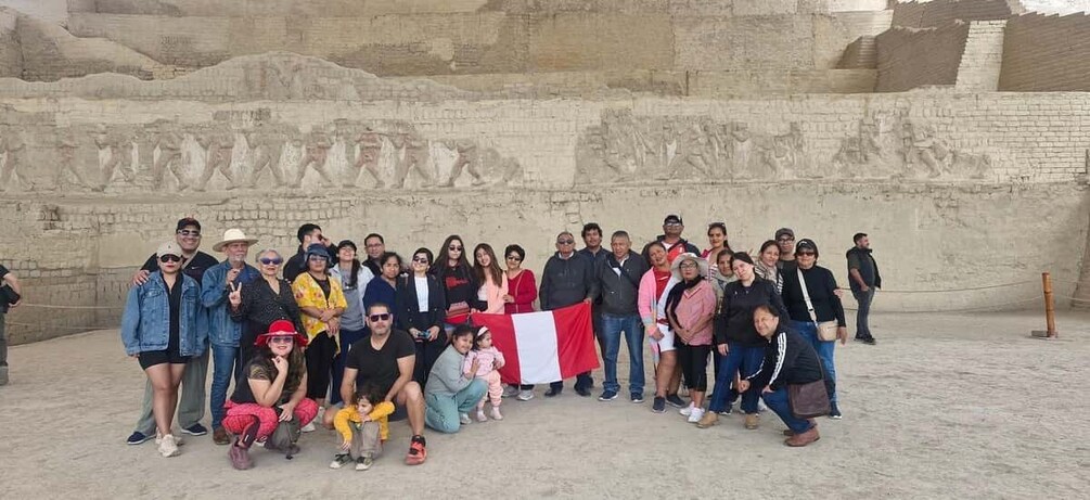 A group of people posing in front of an ancient wall with hieroglyphics. 3