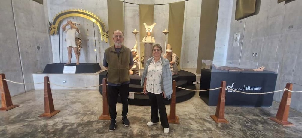 A museum exhibit with a central figure in a white robe and a golden arch. 5