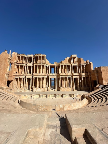 An ancient amphitheater with stone steps and columns. 2