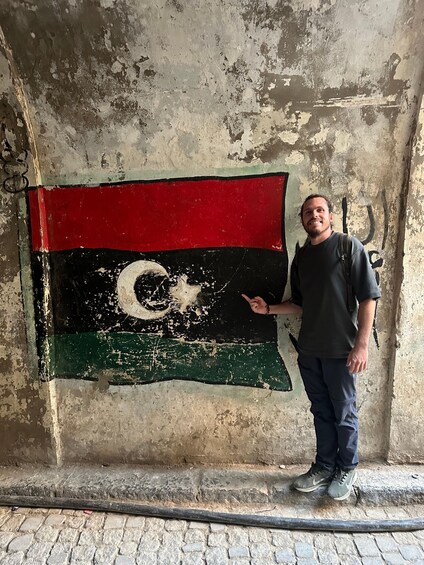 A person standing next to a wall with a flag painted on it. 3