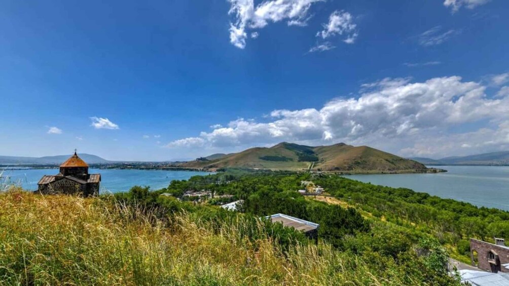 A coastal landscape with a church, a lake, and hills in the background. 3