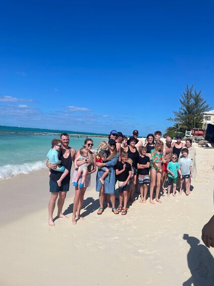A group of people on a sandy beach with the ocean in the background. 4
