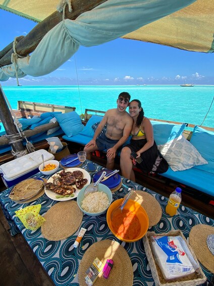 A couple on a boat with a table full of food and drinks. 5
