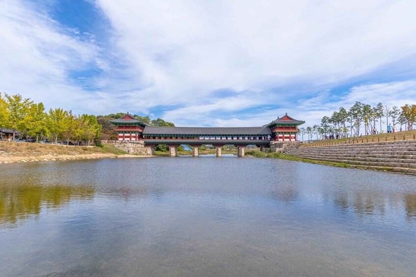 A traditional Korean bridge over a calm river, surrounded by trees and a clear sky. 3